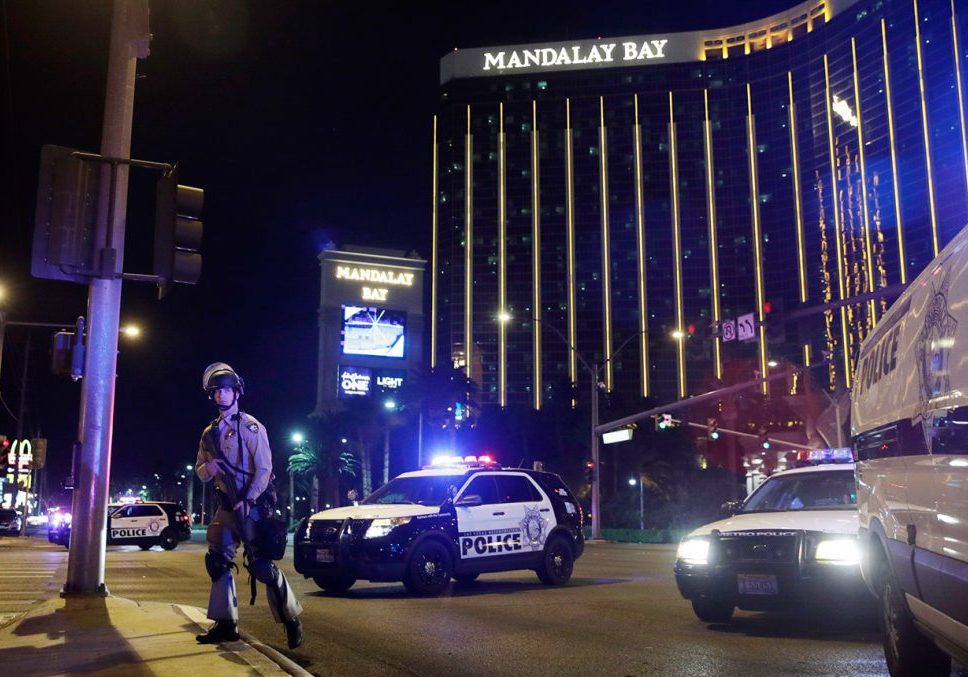 Police officers stand along the Las Vegas Strip the Mandalay Bay resort and casino during a shooting near the casino, Sunday, Oct. 1, 2017, in Las Vegas. (AP Photo/John Locher)